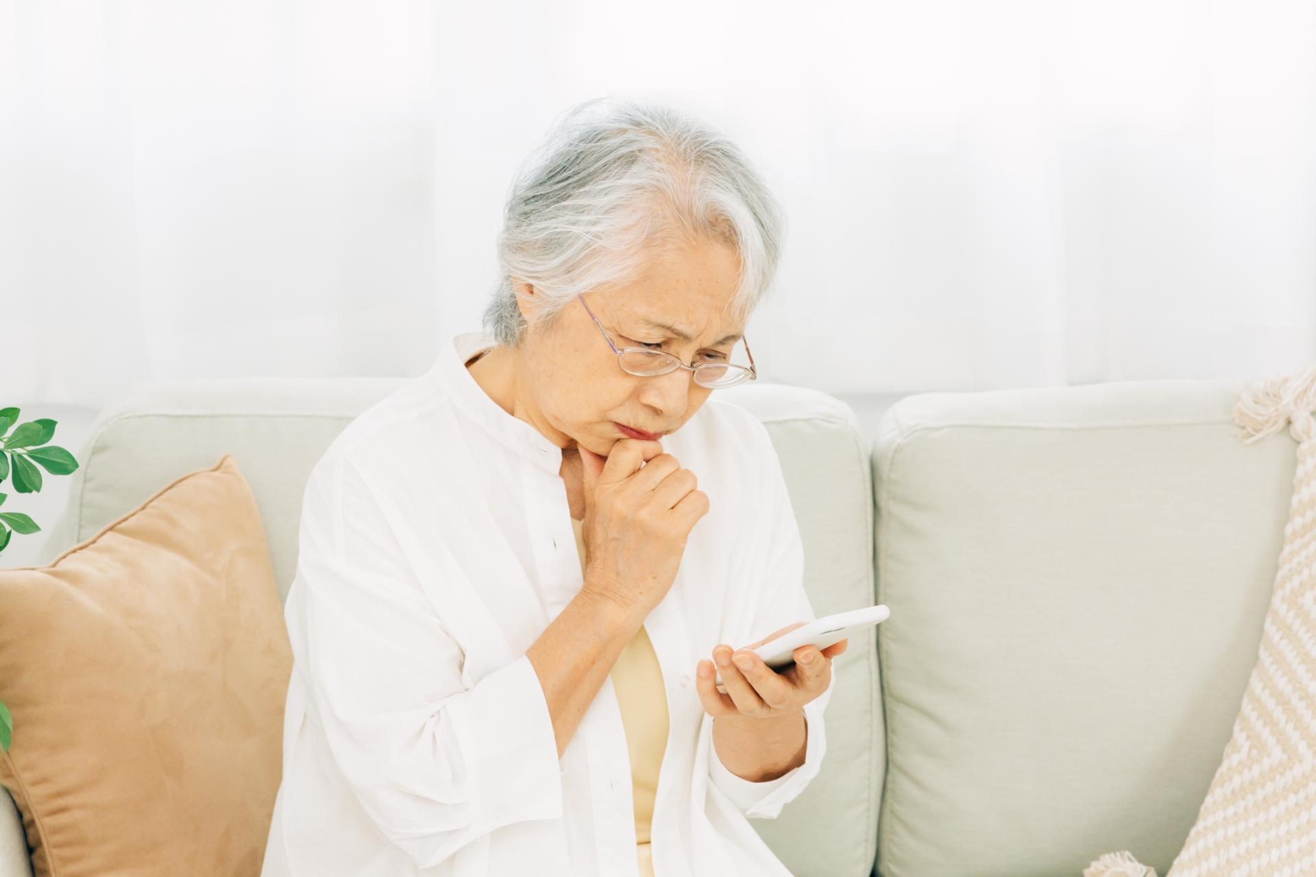 スマホを見て悩む高齢者　イメージ