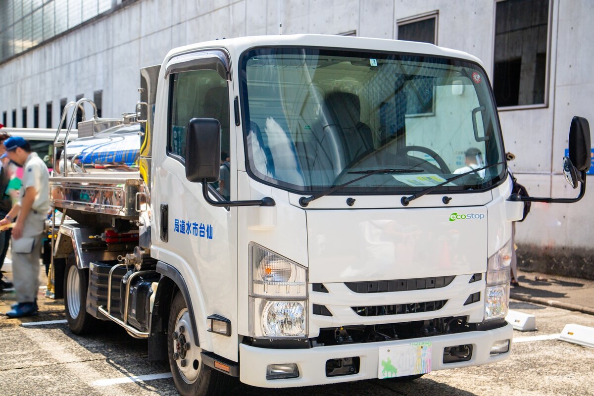 災害時に出動した給水車と給水を受ける人