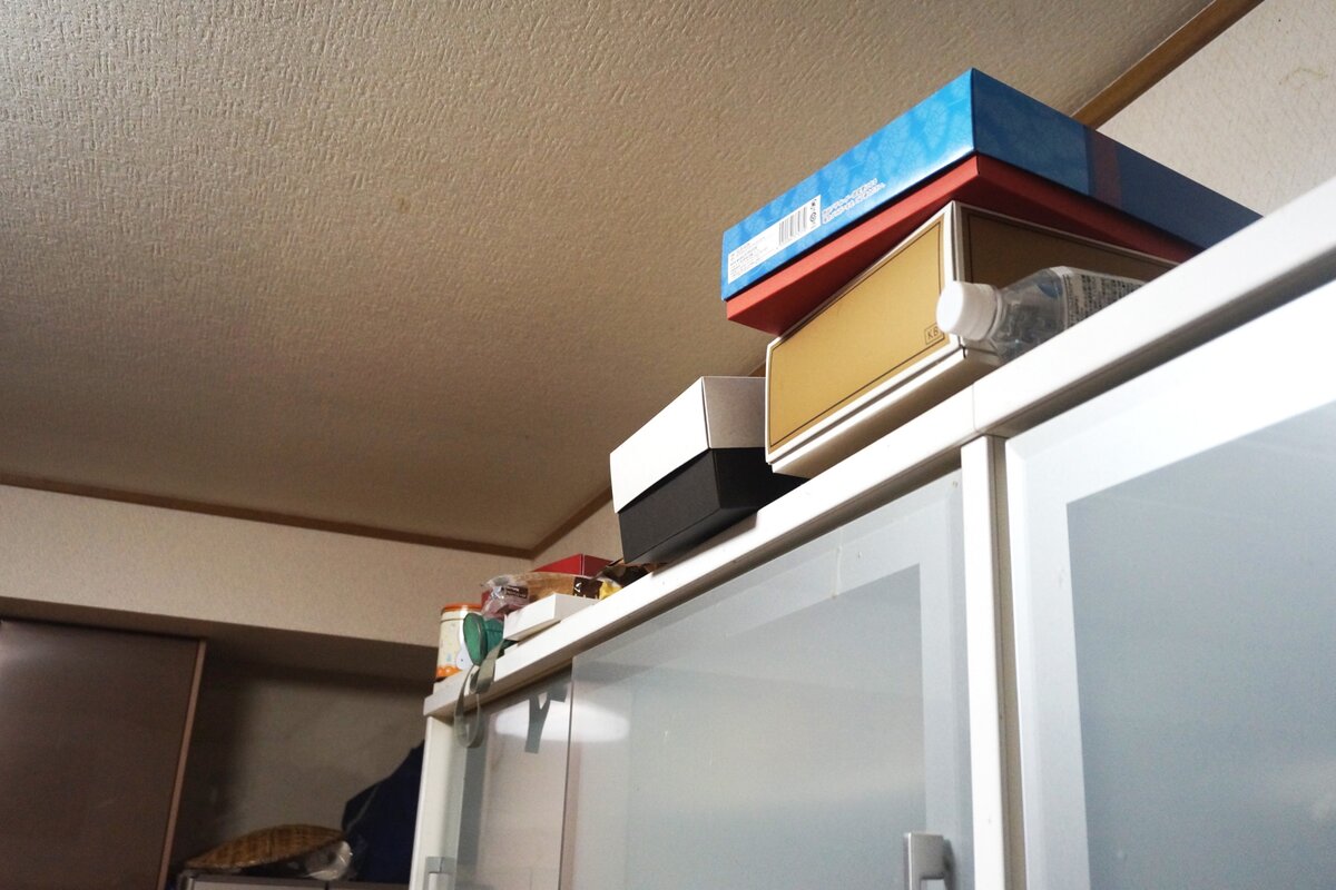 食器棚の上に収納しきれない荷物が積み上げられている様子